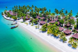 Teil einer Insel mit kleinen Häusern und Palmenstrand