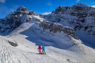 Zwei Menschen auf Skiern laufen durch eine verschneite Berglandschaft