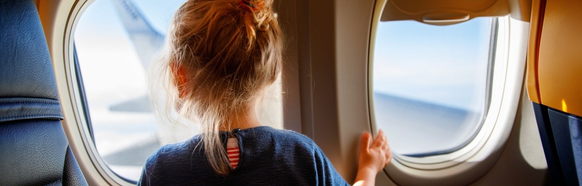 Mädchen schaut aus dem Fenster eines Flugzeuges