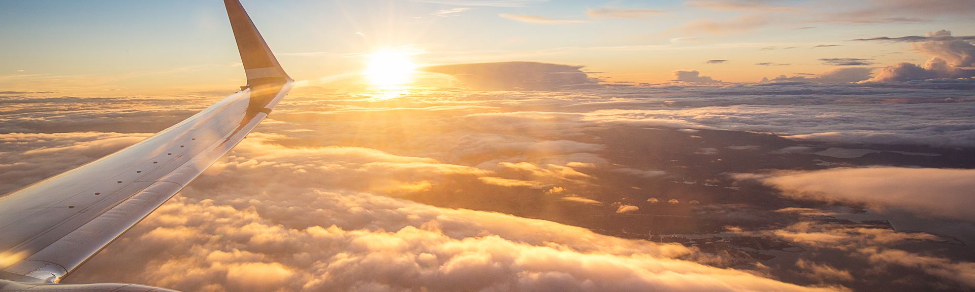 Sonnenuntergang über den Wolken aus einem Flugzeugfenster aus
