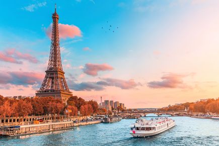 Flusskreuzfahrtschiff auf der Seine neben dem Eiffelturm in Paris