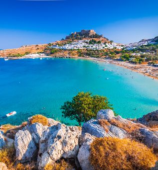 Bucht in Griechenland mit Strand und einer Stadt im Hintergrund