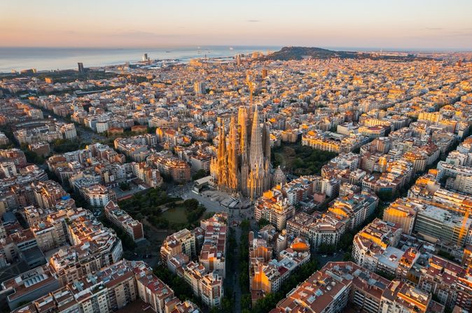 Barcelona von oben bei Sonnenuntergang, im Hintergrund das Meer