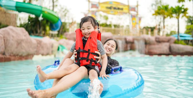 Mutter und Tochter auf einem Pool Floatie in einem Wasserpark
