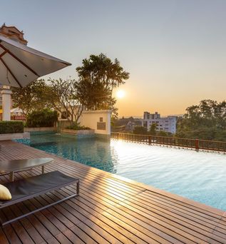 Pool mit zwei Liegen bei Sonnenuntergang