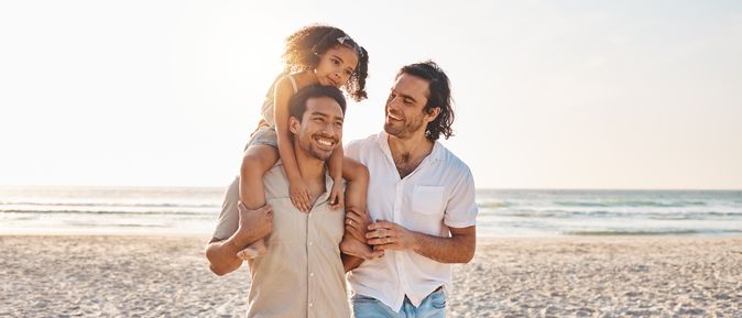 Eine Familie am Strand, Tochter sitzt auf den Schultern des Vaters
